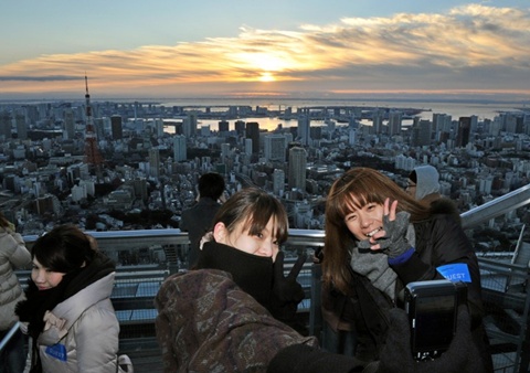 People take pictures of the sunrise on New Year's Day at the open-air Sky Deck of Roppongi Hills, some 238 metres (780 ft.) above ground level in Tokyo on January 1, 2013.